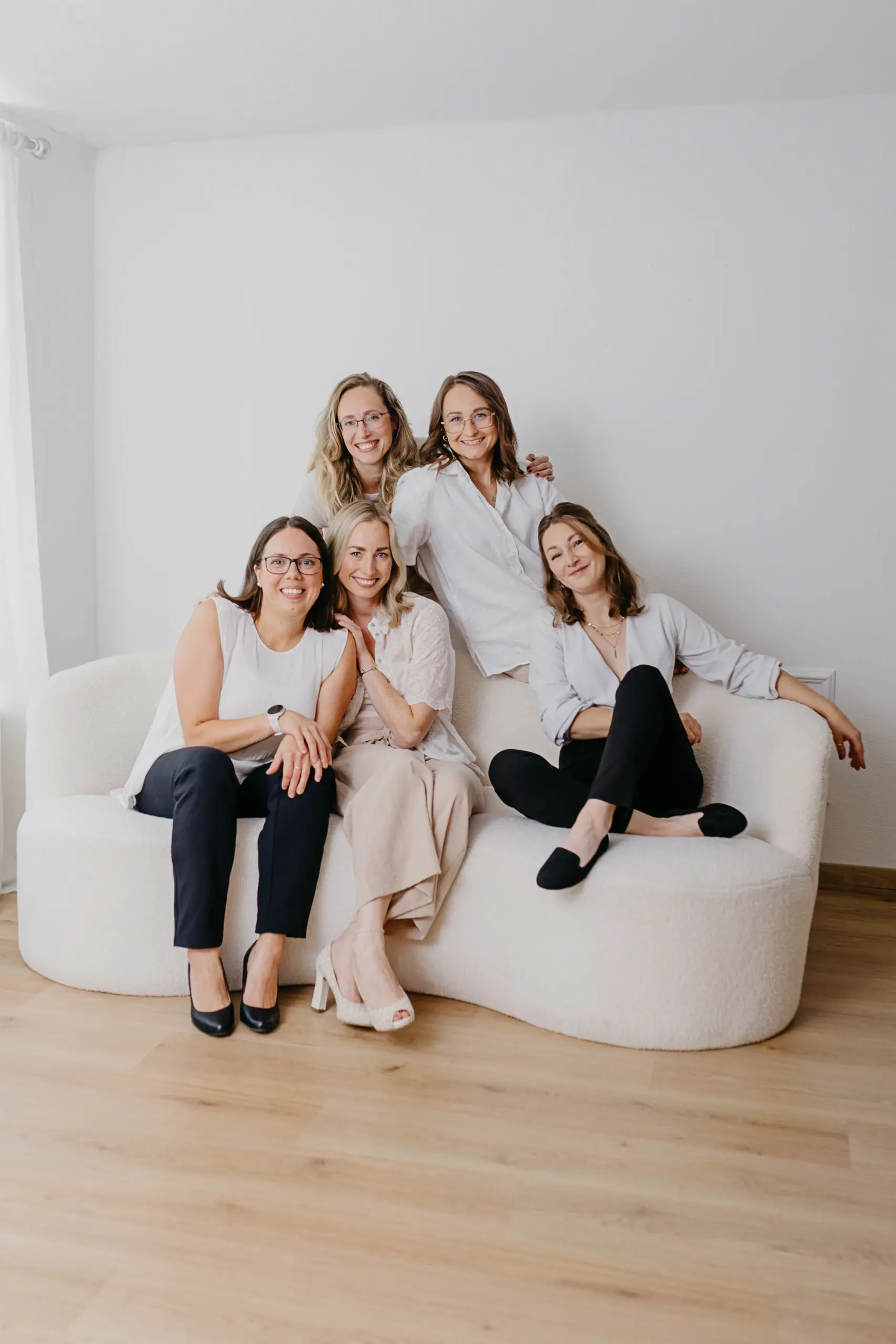 Die fünf Gründerinnen auf einem Sofa sitzend und in die Kamera schauend.